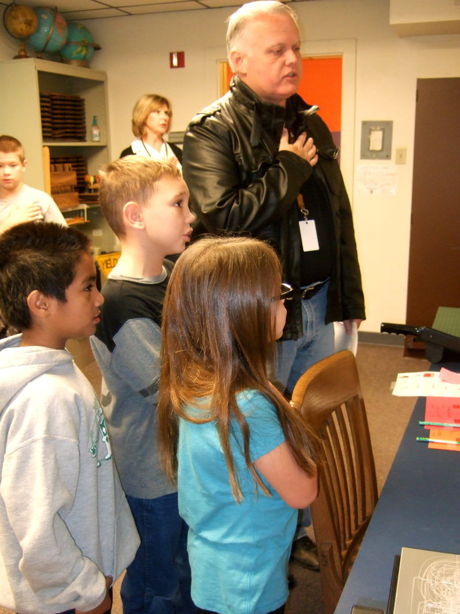 Image: Saying the Pledge of Allegiance over the loud speaker.