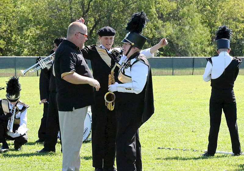 Image: Assistant band director David Graves covers the details with assistant drum major Emily Stiles and drum line captain Whitney Wolaver.