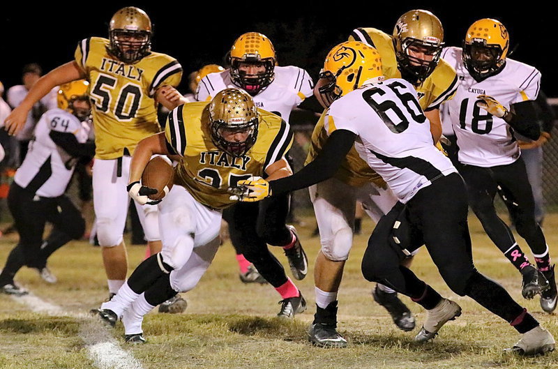 Image: Shad Newman(25) gets blocks from Zain Byers(50) and Kevin Roldan(60) as he fights for extra yards.