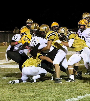Image: Shad Newman(25) takes out the legs while Cody Medrano(75) tackles a Cayuga runner from behind.