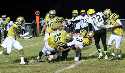 Image: Shad Newman(25) and Coby Bland(40) combine to bring down Cayuga’s top Wildcat runner.