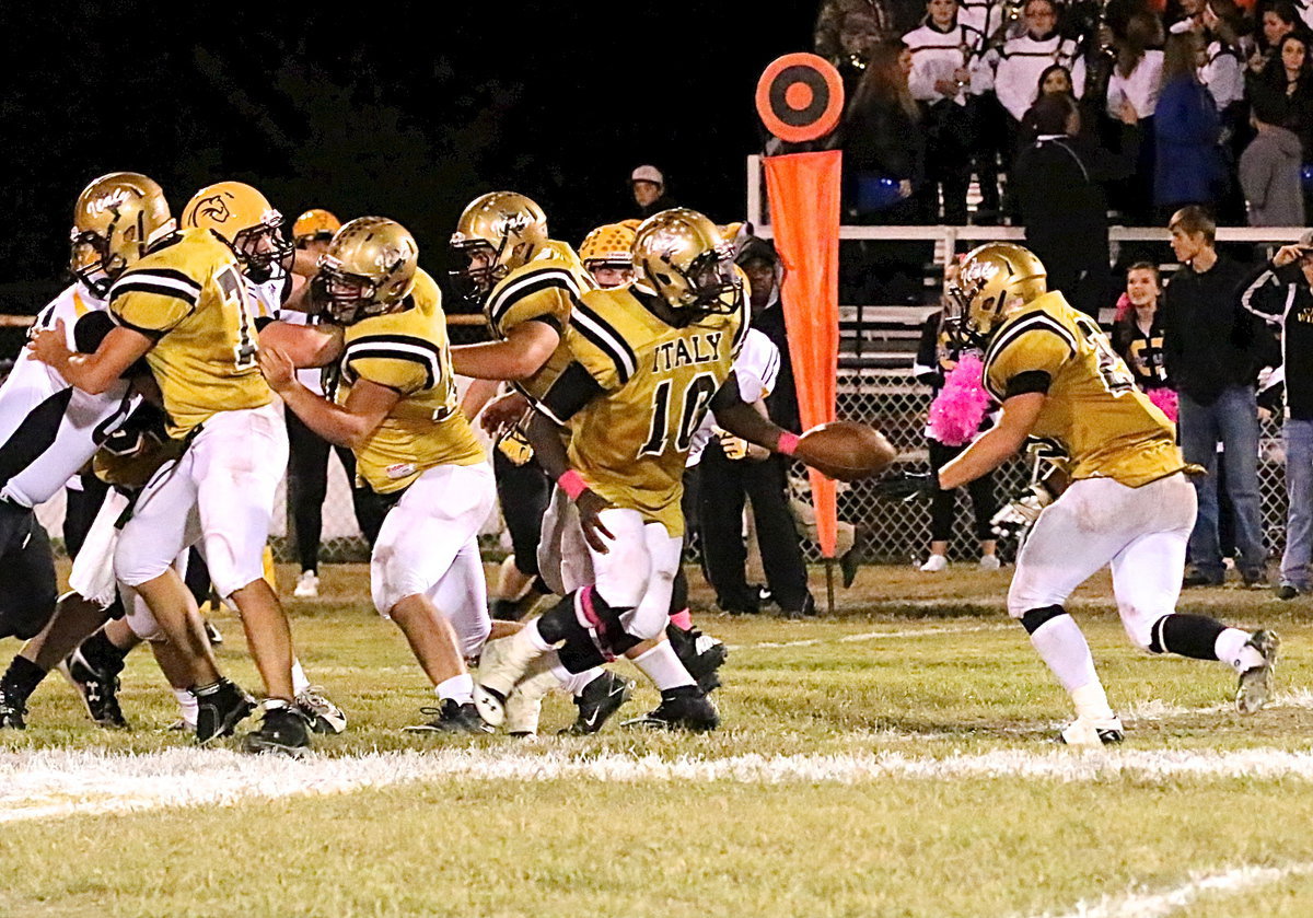 Image: Cody Medrano(75), Zain Byers(50) and Kevin Roldan(60) create a gap for their backfield as quarterback TaMarcus Sheppard(10) turns to hand off.