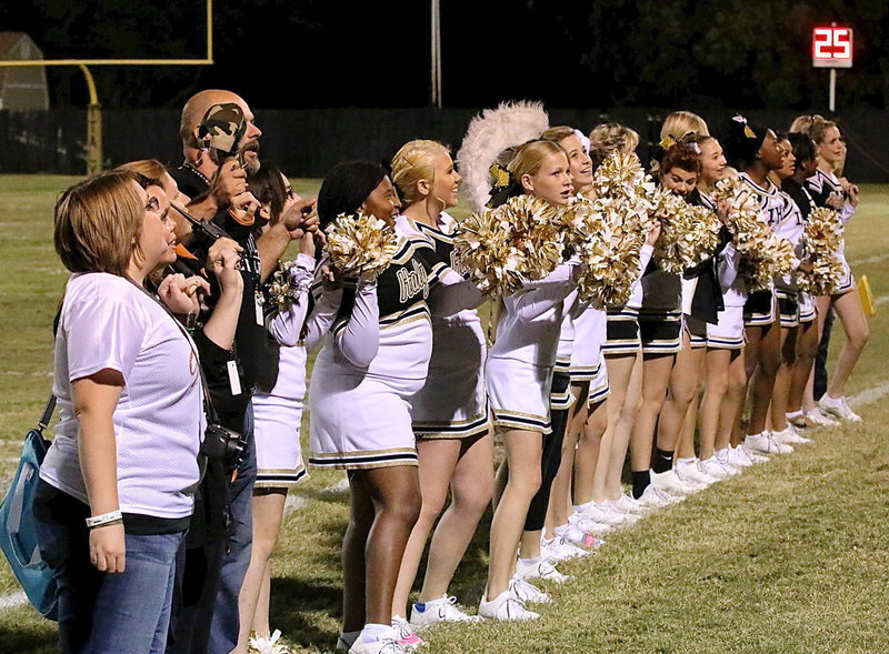 Image: Catherine Hewitt, Erica Miller and Principal Lee Joffre join the cheerleaders during the playing of the school song.