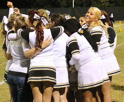 Image: Sydney Weeks and her cheer mates huddle on homecoming.