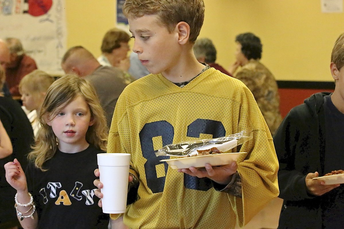 Image: Creighton Hyles grabs some grub while sporting the old jersey of his father, Charles Hyles(83), who played for the Gladiators back in the 80s.