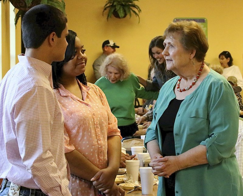 Image: Reid Jacinto and Amber Mitchell visit with Wanda Scott at the meal.