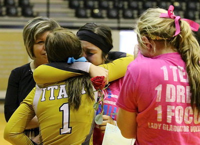 Image: Monserrat Figuera(15) is presented with gifts after playing her final home game as a senior on the Lady Gladiator Volleyball team. Figueroa’s mother, Blanca Figueroa, looks on as teammates Bailey Eubank(1) and Madison Washington(10) make the presentation while fighting back the tears.