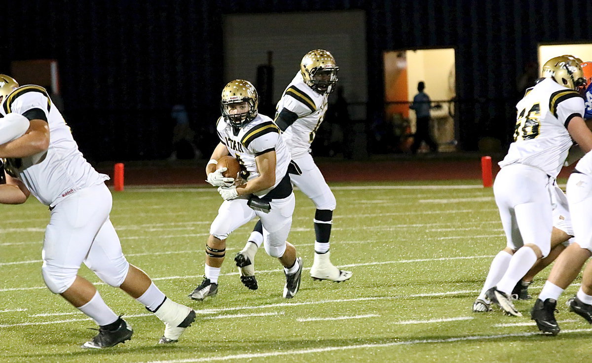 Image: TaMarcus Sheppard(10) hands off to Hunter Merimon(9) who sees daylight thanks to Kevin Roldan(60), blocking left, and Kyle Fortenberry(66), blocking right.