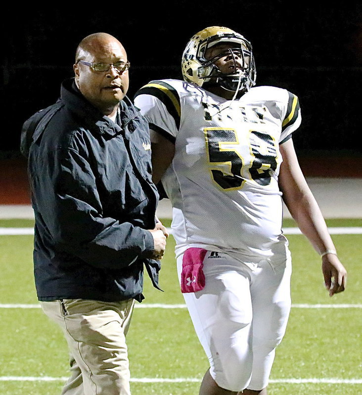 Image: Assistant coach Larry Mayberry, Sr., congratulates his exhausted son, Darol Mayberry(58), after the senior lineman helped lead his team to a fourth-quarter comeback.