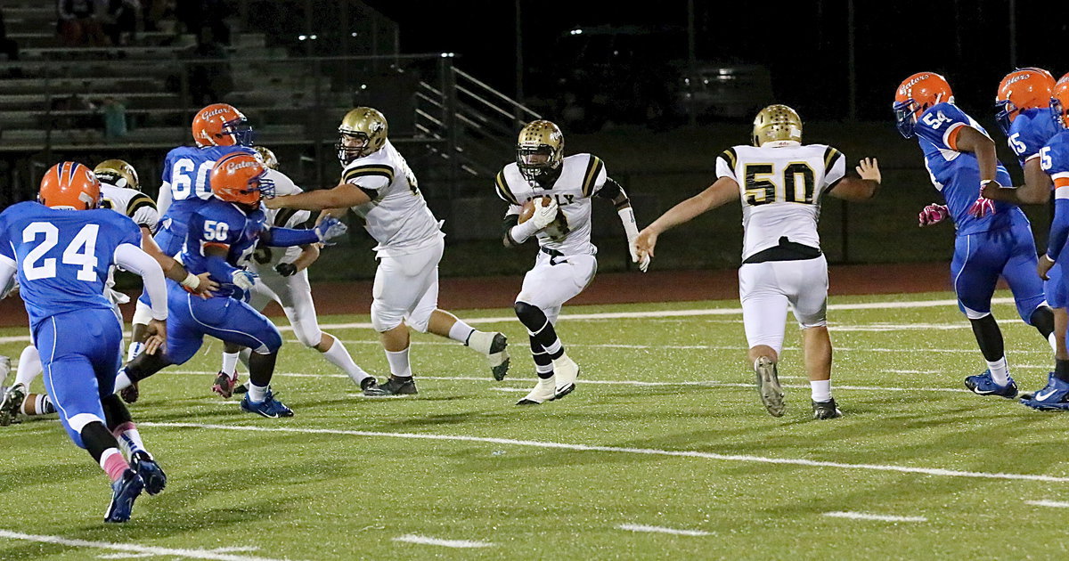 Image: Trevon Robertson(3) finds running room behind Kevin Roldan(60) and Zain Byers(50) for a gain of 9 yards.