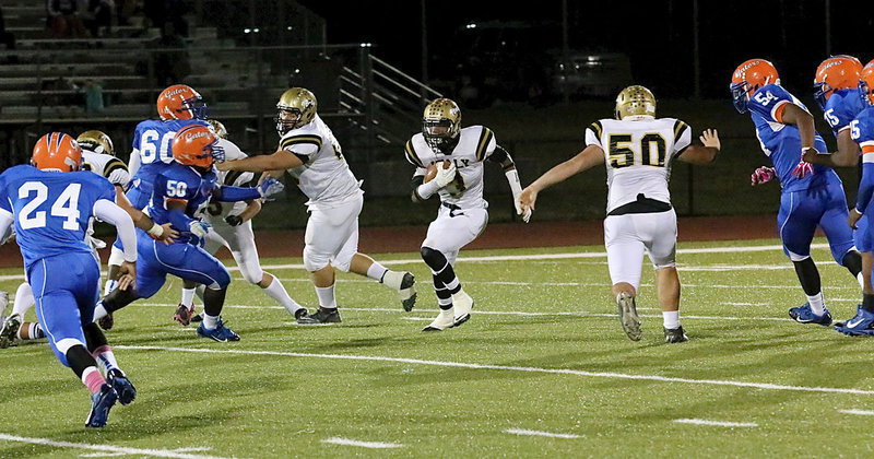 Image: Trevon Robertson(3) finds running room behind Kevin Roldan(60) and Zain Byers(50) for a gain of 9 yards.