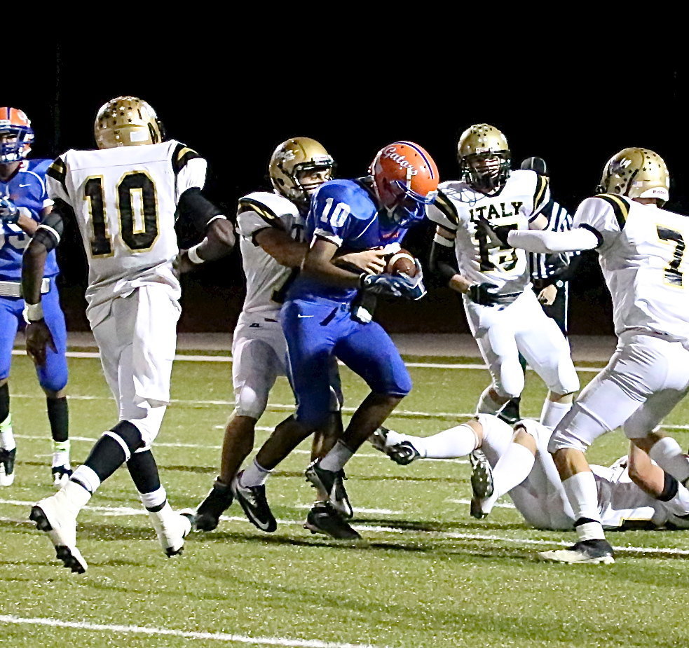 Image: Cody Medrano(75) wrestles down a Gator receiver as teammates TaMarcus Sheppard(10), Cody Boyd(15) and Ryan Connor(7) move in to assist.