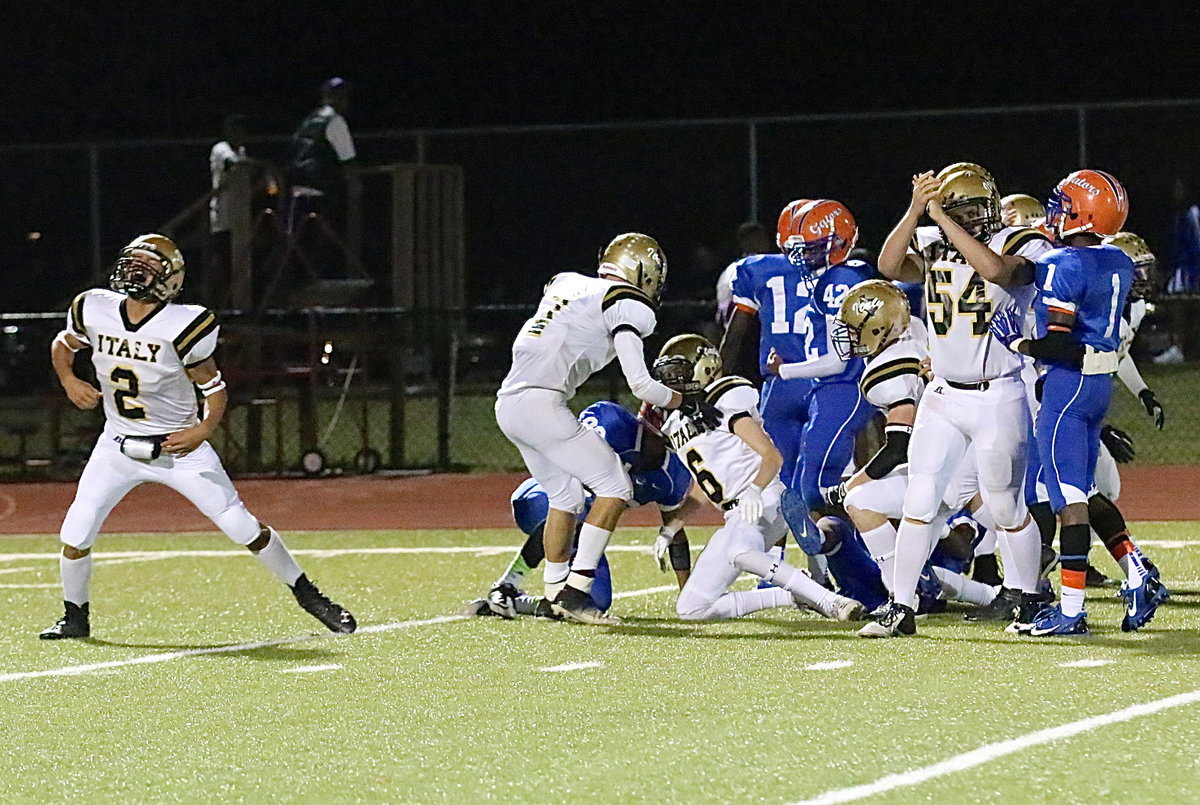 Image: Italy’s Joe Celis(2) and Bailey Walton(54) celebrate a tackle by sophomore Clayton Miller(6) as Ryan Connor(7) helps Miller to his feet.