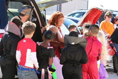 Image: Megan Brewer passes out candy to the Stafford students from the trunk of her vehicle.