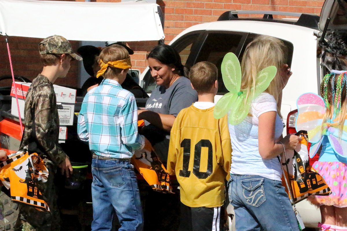 Image: Stafford Elementary’s PTO president Tessa South passes out candy from the back of a Monolithic, Inc. Kubota.