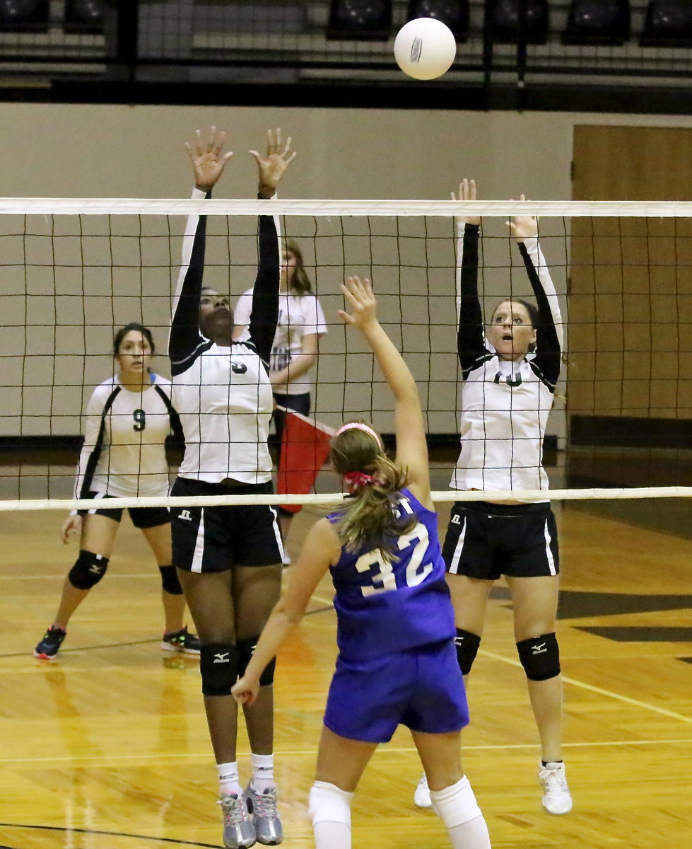 Image: JV Lady Gladiators Janae Robertson(5) and Brooke DeBorde(10) go for the block with teammate Elizabeth Garcia(9) backing them up.