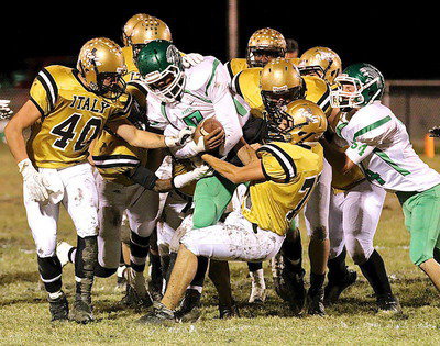 Image: Coby Bland(40) goes for the strip while Cody Medrano(75) and several of their Gladiator teammates pull a Kerens running back backwards.