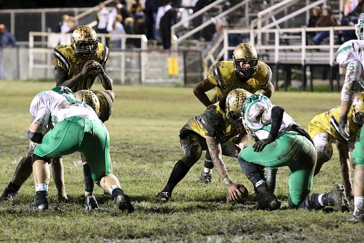 Image: Center Kyle Fortenberry(66) was spot-on snapping under muddy conditions as quarterback TaMarcus Sheppard(10) calls for the ball.