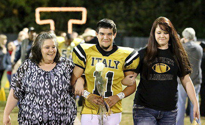 Image: Gladiator senior Tyler Anderson(11) is escorted by his mother Amy Anderson and senior classmate Paige Westbrook.