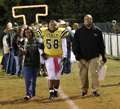 Image: Gladiator senior Darol Mayberry(58) is escorted by his mother Dorothy Mayberry and and father/coach Larry Mayberry, Sr.