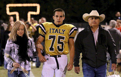 Image: Gladiator senior Cody Medrano(75) is escorted by his mother Jane Medrano and father Jerry Medrano.