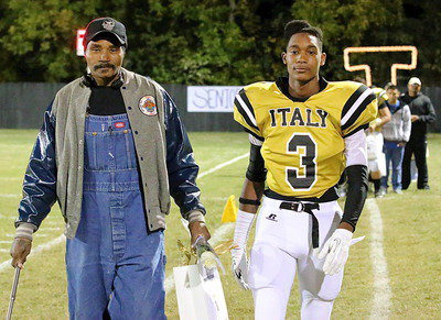 Image: Gladiator senior Tre Robertson(11) is escorted by his father Johnny Williams.