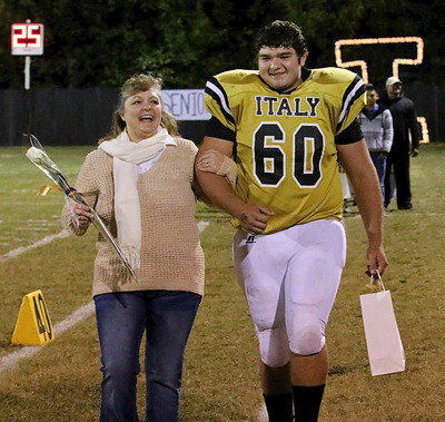Image: Gladiator senior Kevin Roldan(60) is escorted by his mother Flossie Gowin as she reacts to her son’s bio being read over the loud speaker.