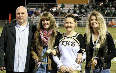 Image: Gladiator senior and cheer captain Taylor Turner is escorted by her father Lee Turner and his wife Emily Turner, and her mother Ronda Cockerham on the right.