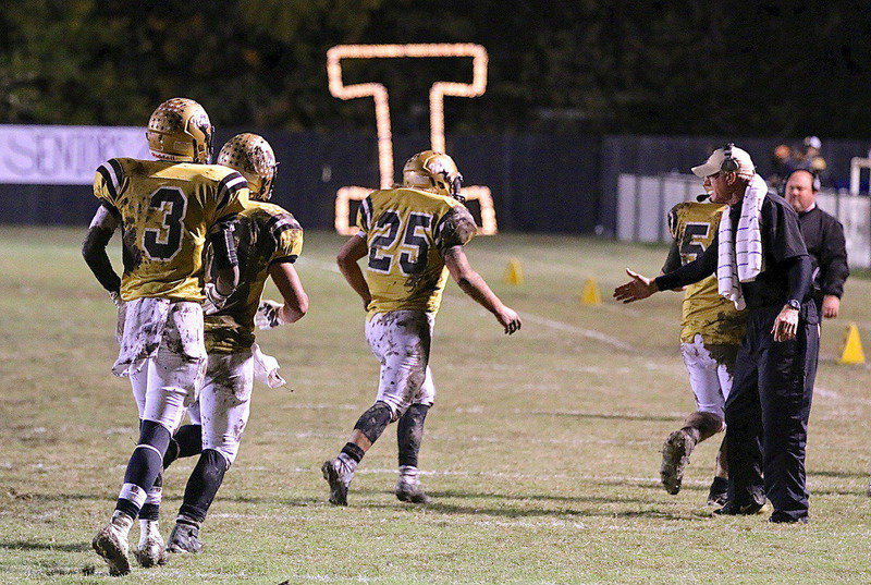 Image: Head coach Charles Tindol congratulates Shad Newman(25), Coby Bland(40) and Trevon Robertson(3).