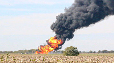 Image: The site of the gas explosion rages on after several construction vehicles were engulfed after unintentionally drilling into the line.