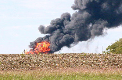 Image: Amazingly, the fire remained centrally located around the damaged rig, unable to scorch the surrounding pasture and farm land due to recent rains.
