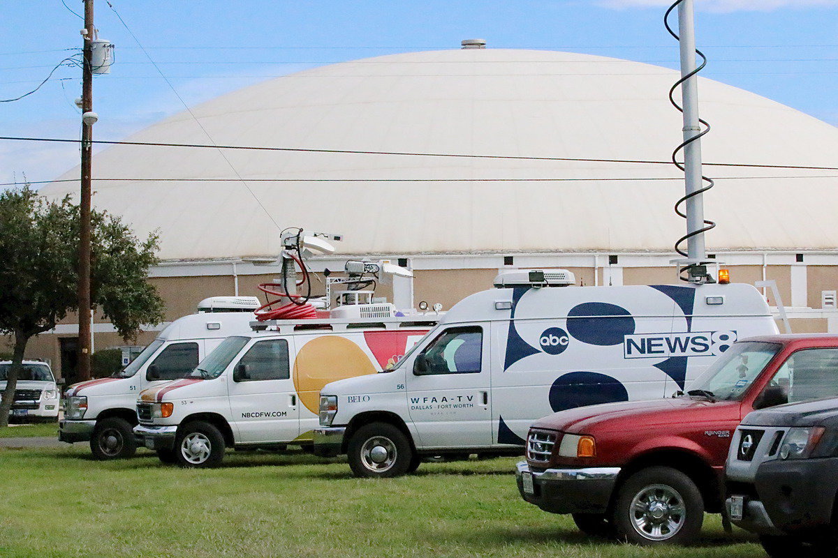 Image: News crews hunker down outside the Italy Coliseum dome-nasium that also serves as a community shelter.