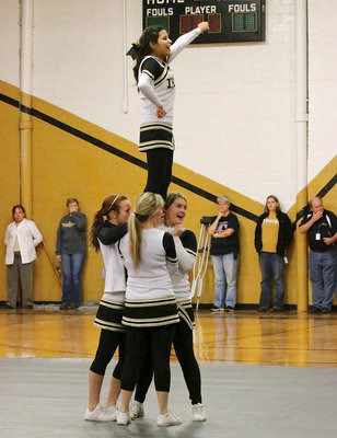 Image: Senior cheerleader Jessica Garcia makes her debut at the top of a stunt with Paige Little, Kelsey Nelson and fellow senior Taylor Turner giving her a hand.