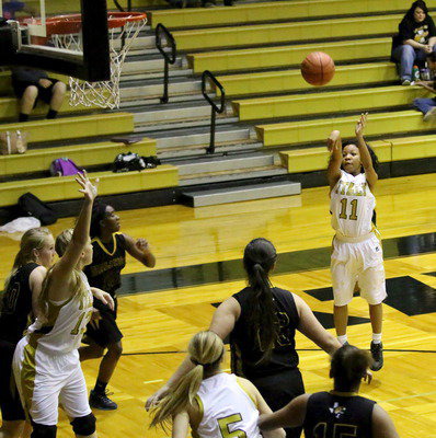 Image: Ryisha Copeland(11) takes her shot with teammates Jaclynn Lewis(13) and Halee Turner(5) in position to rebound.