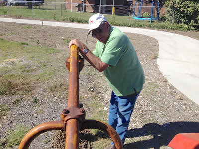 Image: Former City of Italy council member, Jimmy Hyles, puts weight on the hole digger used to make holes for the cable wire posts.