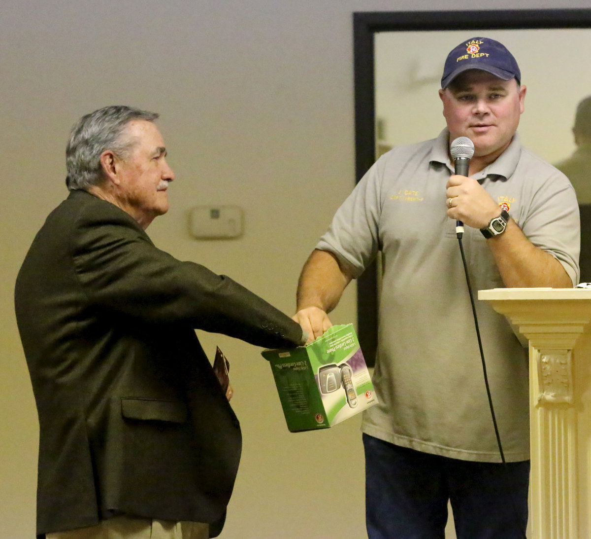 Image: Fire District Board treasurer James Steele draws a name to see who wins gift certificates as Jackie Cate holds the box of names.