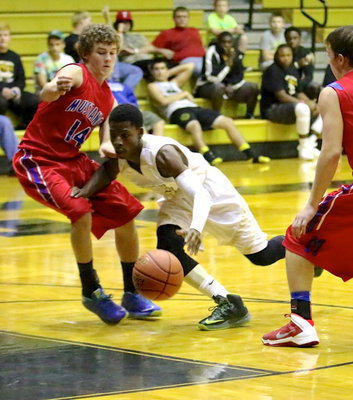 Image: During the JV game, Eric Carson(2) forces his way between two Mustangs.