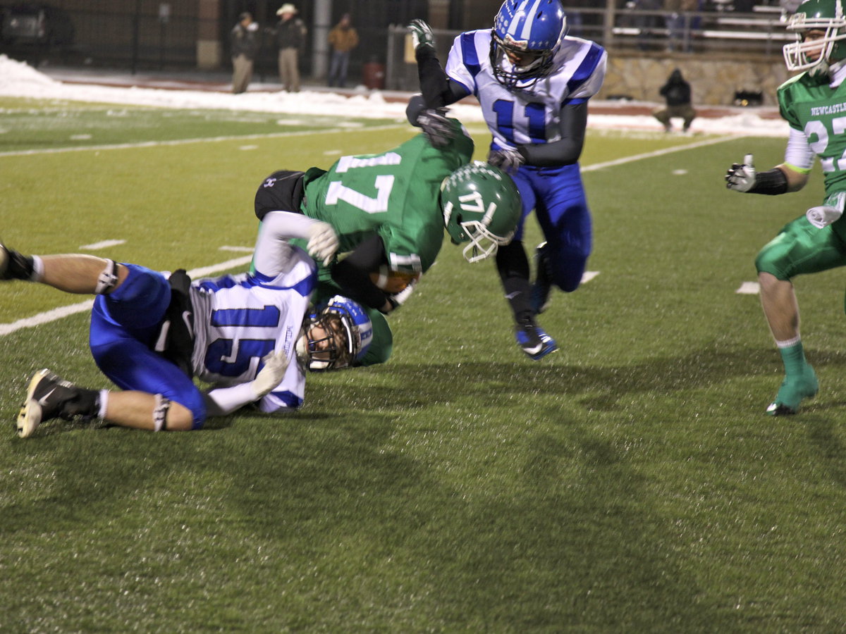 Image: Bryan Fedrick (15) and Jaquay Brown (11) take down a Bobcat.