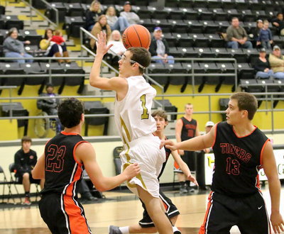 Image: Ryan Connor(1) spins away from Tiger defenders to get a shot up.