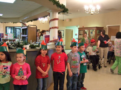 Image: Here are the elves singing Rudolph the Red Nosed Reindeer.