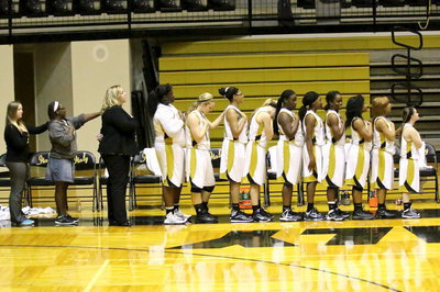 Image: The Lady Gladiators, head coach Melissa Fullmer and team managers Tia Russell and Brenya Williams during the National Anthem.