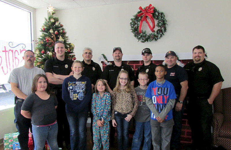 Image: Participating in the Shop with a Hero program this the holiday season were: (Front row L-R): Dixie Brady, Courtni Bland, Eden Forbus, Zoe Hogan, Jacob Phipps and Elyjah Smith. (Back row L-R): Firefighter Chris Kimmons, Officer Mike Richardson, Officer Mike Stevens, Sgt. Shawn Martin, Cpl. Daniel Pitts, Capt. Jackie Cate and Officer Eric Tolliver