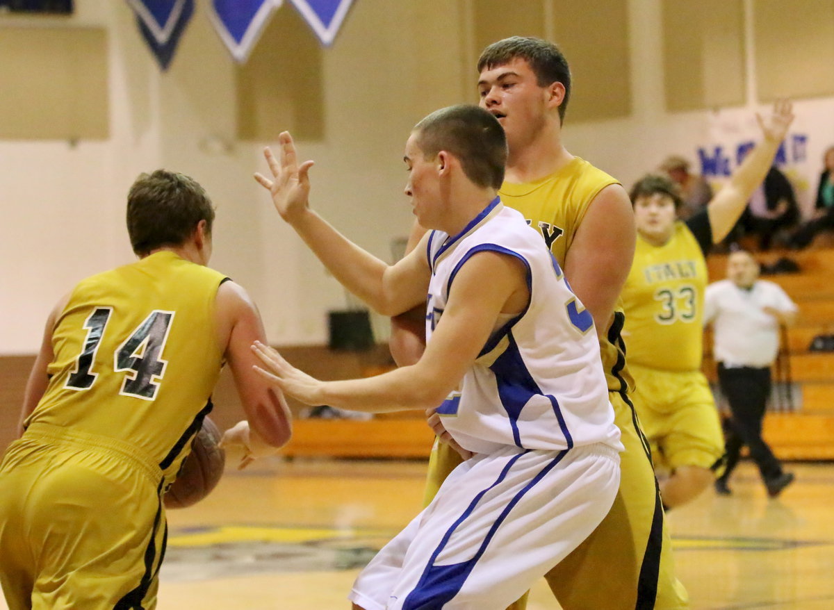 Image: Bailey Walton(14) dribbles around a screen set by Zain Byers(21) as teammate Kevin Roldan(33) calls for the ball.