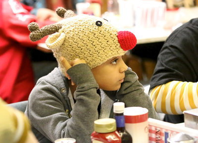 Image: Aliyah Turner shows her Christmas spirit with her Rudolph hat while dining inside The Uptown Cafe.