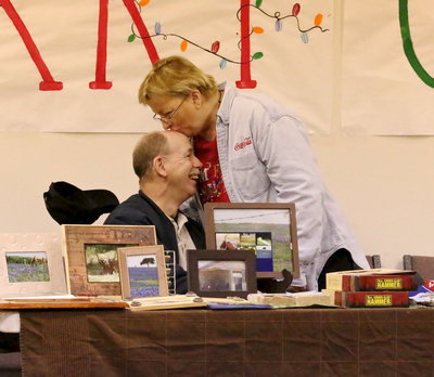 Image: Photographer Anne Sutherland gives her hubby, Tommy Sutherland, a Christmas kiss.
