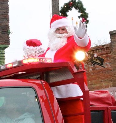 Image: There he is! Santa waves to kiddos.
