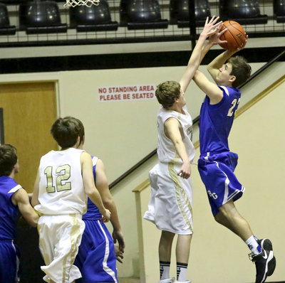 Image: JV Gladiator Michael Moore(4) defends the paint.
