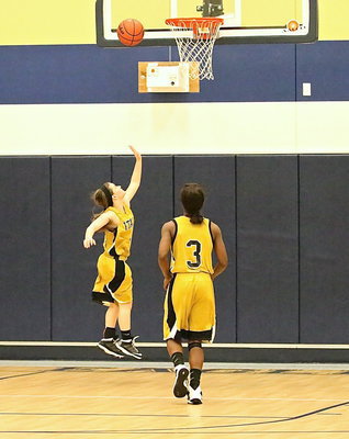 Image: Tara Wallis(4) puts in a layup with her left as teammate Kortnei Johnson(3) tracks the play.