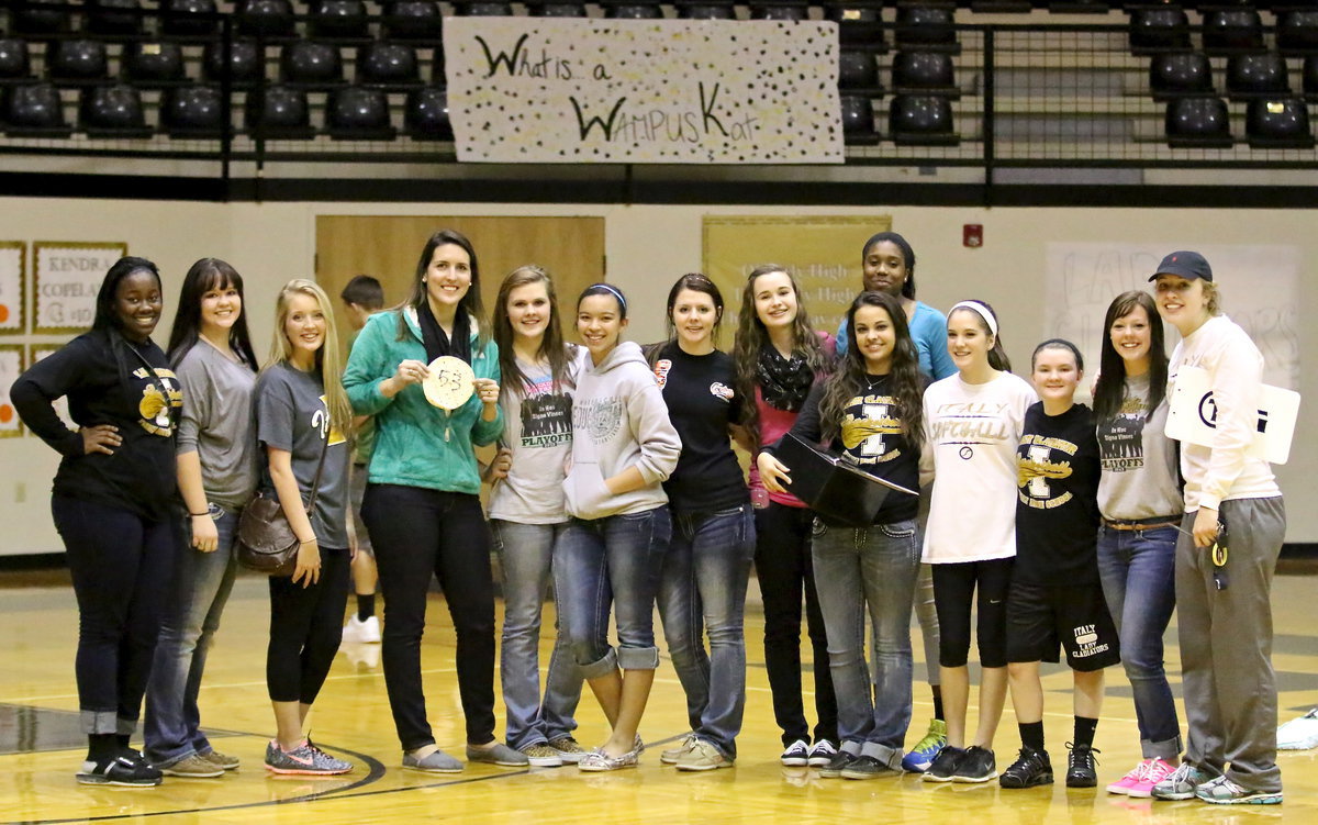 Image: Tortilla Toss winner and Lady Gladiator alumni Megann Lewis Harlow (behind the tortilla) poses with current members of the Lady Gladiator Softball team, including (L-R): Taleyia Wilson, Paige Westbrook, Hannah Washington, #53, Lillie Perry, April Lusk, Brooke DeBorde, Amber Hooker, Ashlyn Jacinto, Janae Robertson, Cassidy Childers, Tara Wallis, Bailey Eubank and little sister, Jaclynn Lewis.