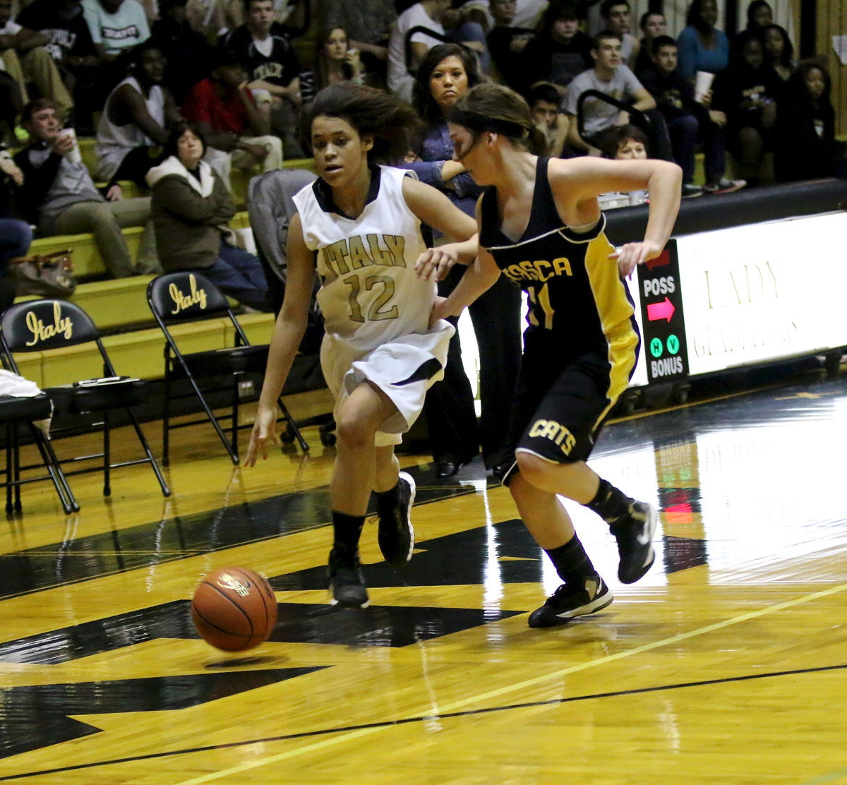 Image: JV Lady Gladiator, Alex Minton(12) fights off an Itasca defender while pushing the ball toward the basket.